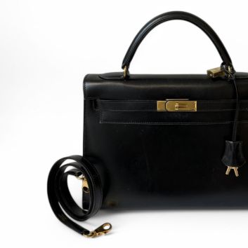 HERMÈS Sac Kelly sellier 32 cm en veau box noir, bijouterie en métal plaqué or, doublure en chèvre noire