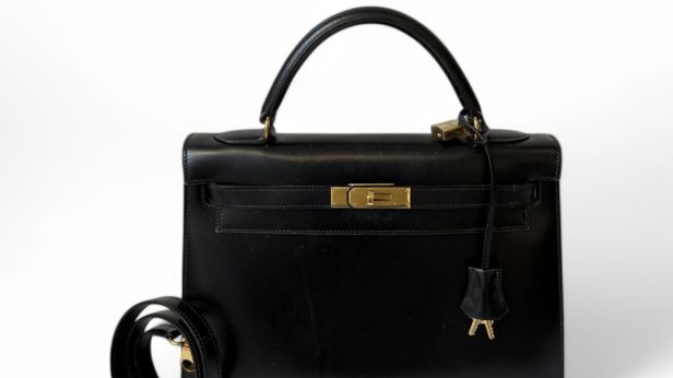 HERMÈS Sac Kelly sellier 32 cm en veau box noir, bijouterie en métal plaqué or, doublure en chèvre noire