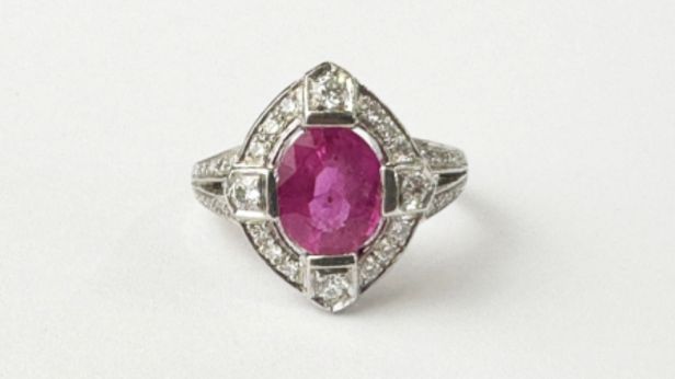 Bague en or gris 18k (750e), ornée d'un saphir rose ovale facetté, dans un entourage losangique rehaussé de diamants