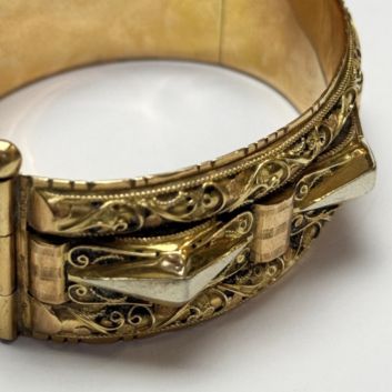 Bracelet manchette en or jaune (750) à décor filigrané et motifs géométriques.