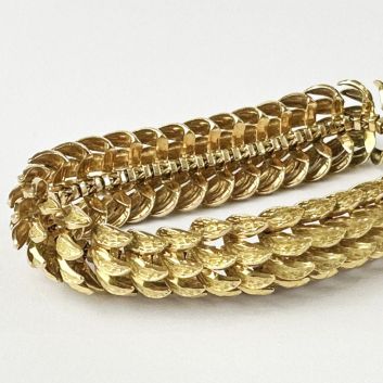 Bracelet souple en or 18k (750e) ajouré, composé de maillons texturés stylisant des plumes