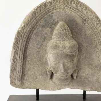 Art KHMER, Cambodge, XIIe/XIIIe siècle. Partie de stèle en grès gris figurant une tête de divinité (Uma ?)