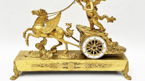 Pendule en bronze doré figurant Cupidon conduisant dans les nuées un char