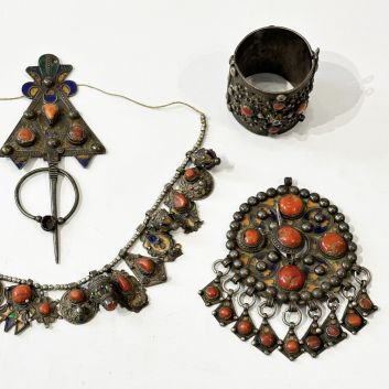 Ensemble de quatre bijoux kabyles en argent (800), émail et cabochons de corail comprenant une fibule