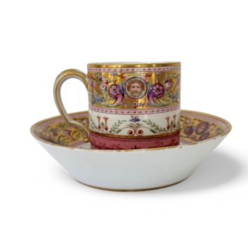 SÈVRES Rare gobelet litron et une soucoupe de 2e grandeur en porcelaine dure, à décor polychrome néoclassique d’une frise de grotesques sur fond or